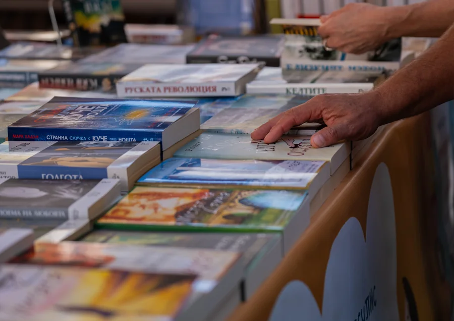 Ръце над книги, подредени на открит щанд